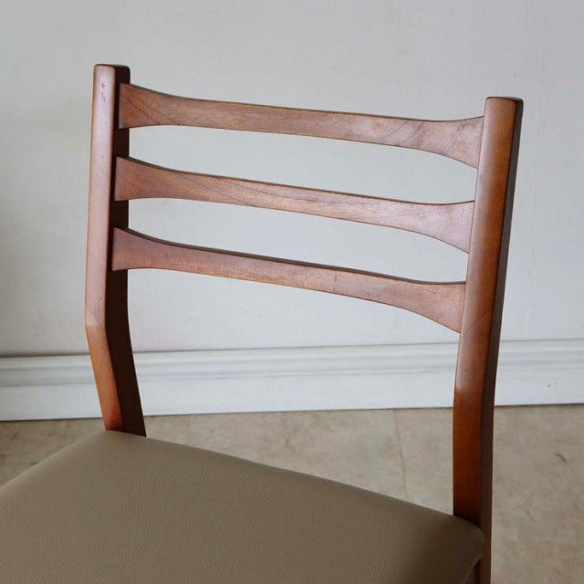 Vintage teak mid-century dining chair backrest with smoothly curved horizontal slats and visible wood grain, British-Denmark .