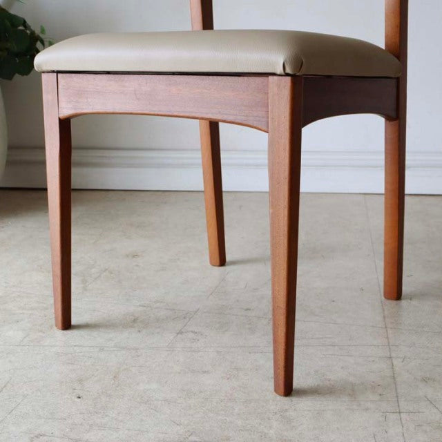 Mid-century vintage British teak dining chair with clean lines, tapered legs, and white upholstered seat from Denmark.