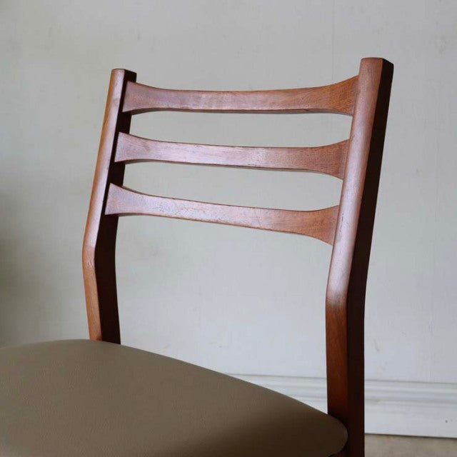 Mid-century vintage teak dining chair with British design, ladder back and smooth wood grain.