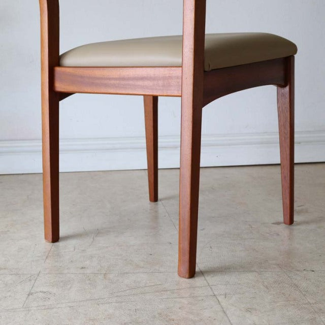 Mid-century vintage teak dining chair with sleek wooden legs and smooth white upholstered seat from British-Danish design.