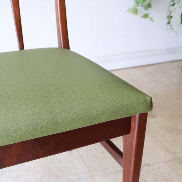 Mid-century British vintage teak dining chair with olive green leather seat and slender tapered legs.