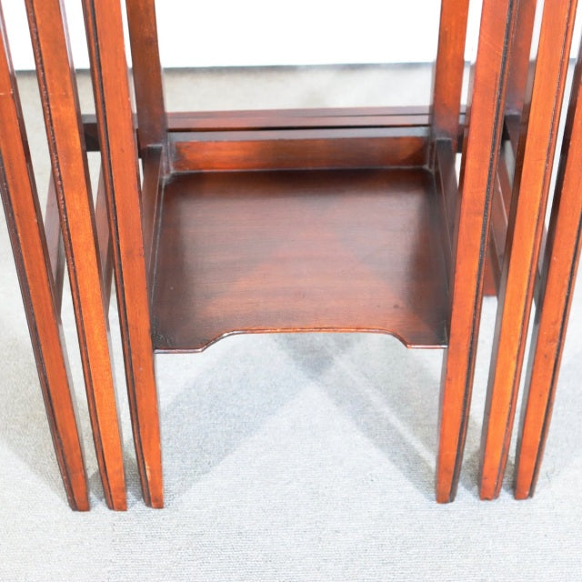 Vintage British teak nesting tables with mid-century design, smooth wood grain, slender straight legs, rich warm finish,.