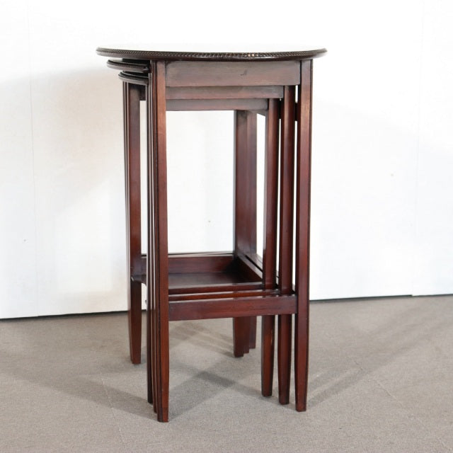 Set of vintage British mid-century teak nest tables with rich wood grain and slender tapered legs, showcasing elegant.