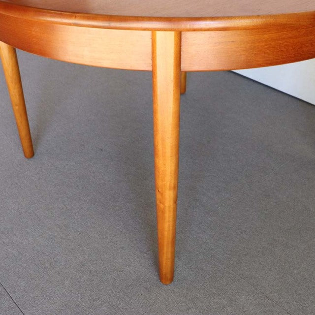 Mid-century British vintage teak dining table leg with smooth wood grain and tapered design.