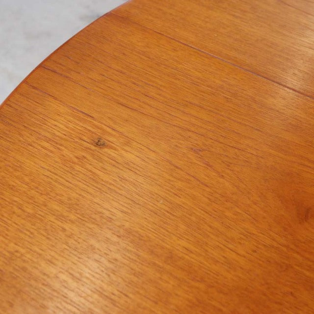 Mid-century vintage British teak round dining table top showing warm wood grain and smooth finish.