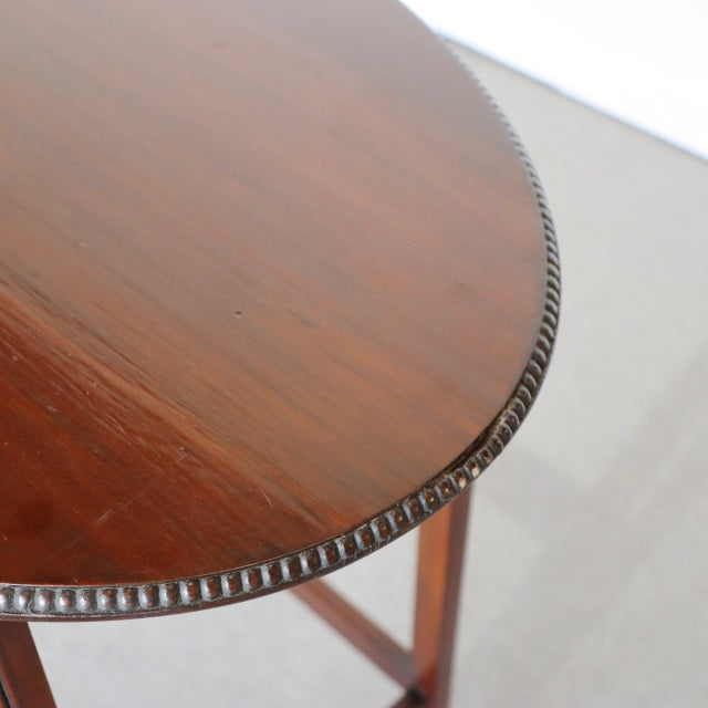 Vintage British mid-century teak nest table with rich wood grain and detailed carved edge trim.
