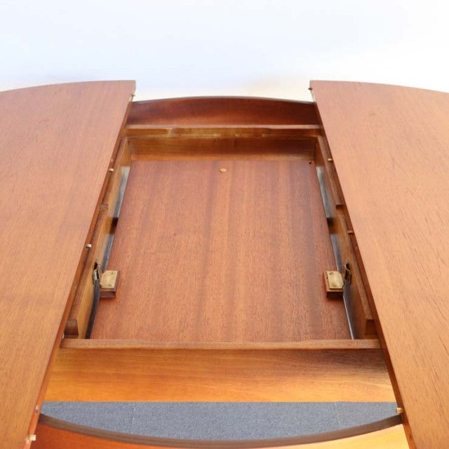 Mid-century vintage teak round dining table with extending leaves, showcasing rich wood grain and sturdy British.