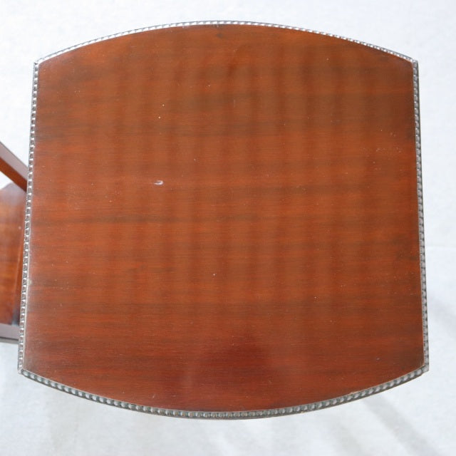 Vintage British mid-century teak nest table top with rich wood grain and brass nailhead trim.