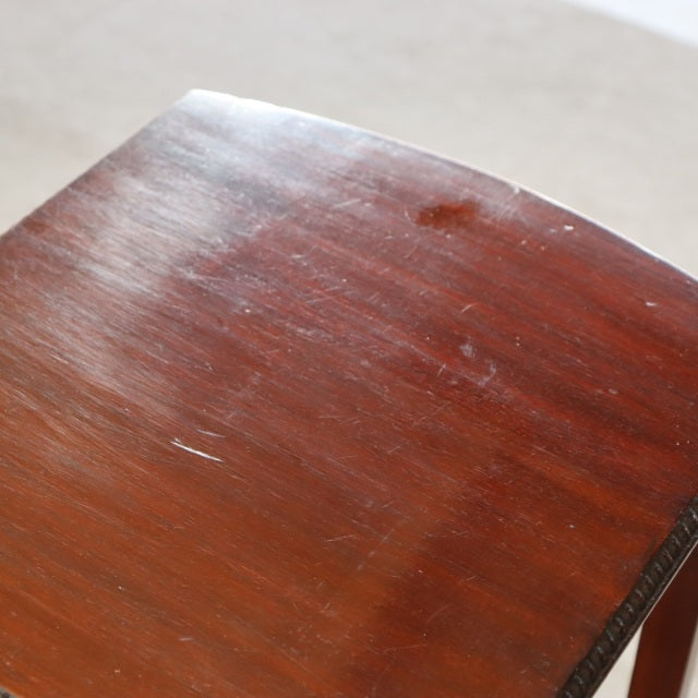 Close-up of vintage British teak nest table top showing rich wood grain and rounded edges with mid-century Danish design.