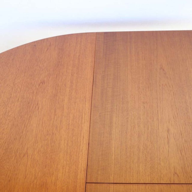 Round vintage teak dining table with mid-century British design, smooth grain surface, and clean edges.