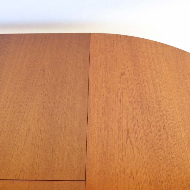 Mid-century British vintage teak dining table with smooth grain and rounded edges, Denmark style.