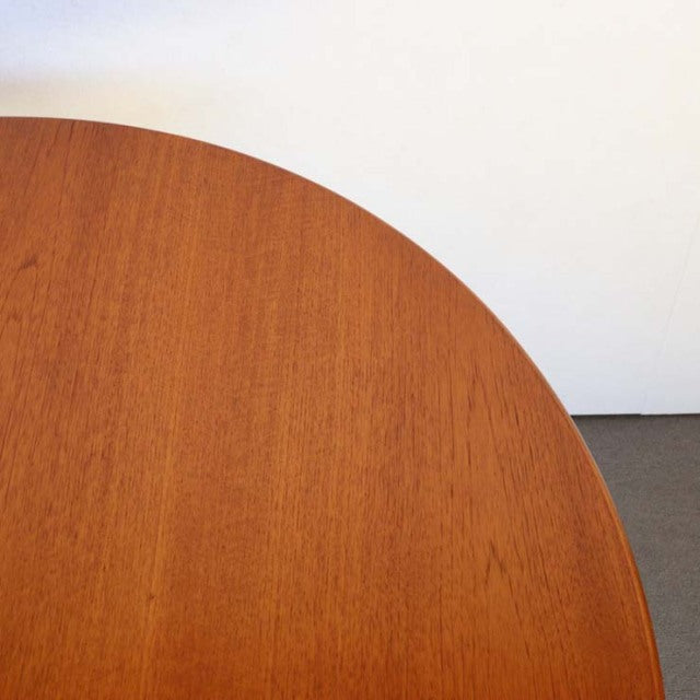 Round vintage teak dining table top showing smooth wood grain and warm mid-century British design.