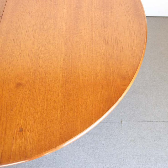 Round vintage teak dining table top showcasing warm wood grain and smooth mid-century British design from Denmark.