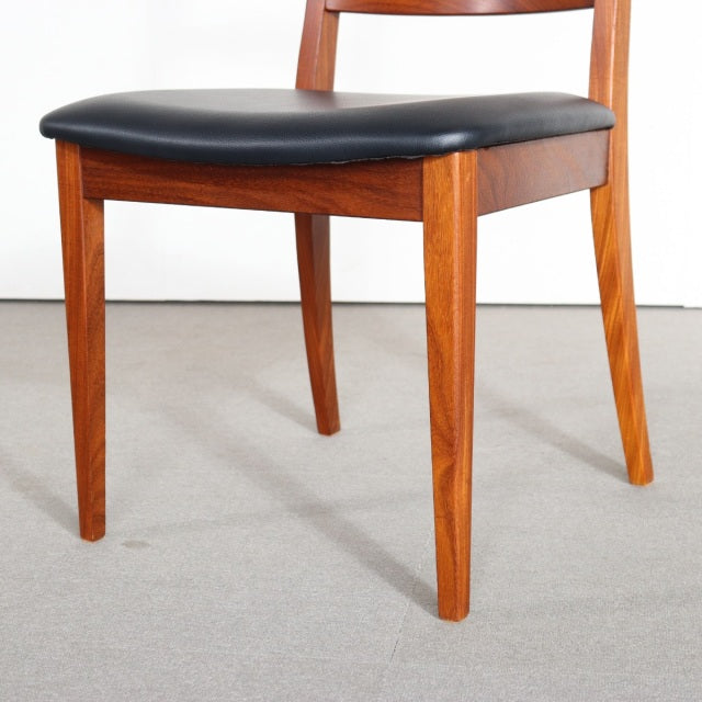 Vintage G-Plan mid-century teak dining chair with black leather seat, sleek tapered legs, and smooth wood grain finish,.