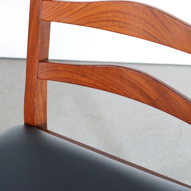 Vintage British G-Plan dining chair with teak wood frame, smooth curved slats, and black upholstered seat.