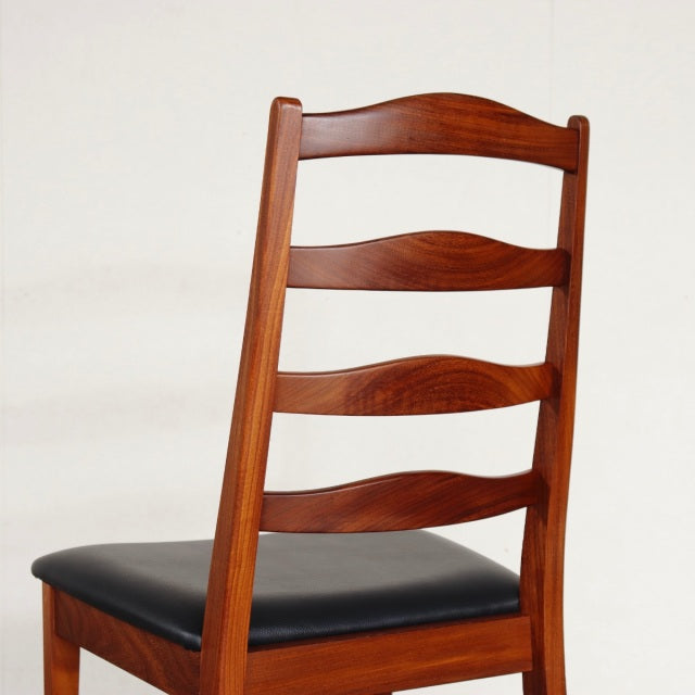Vintage British G-Plan teak dining chair with ladder back and black cushioned seat, mid-century Denmark style.