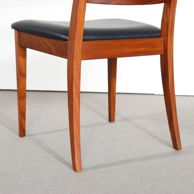 Vintage G-Plan teak dining chair with mid-century British design, black cushioned seat, tapered legs, smooth wood grain.