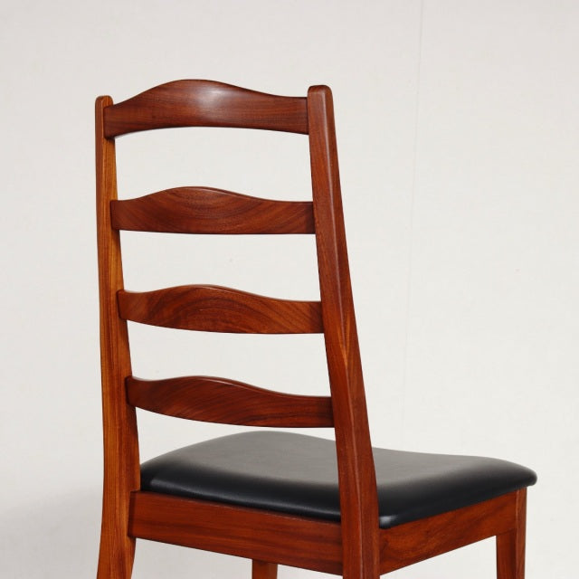 Vintage G-Plan teak dining chair with British mid-century design, curved slat back and black upholstered seat.