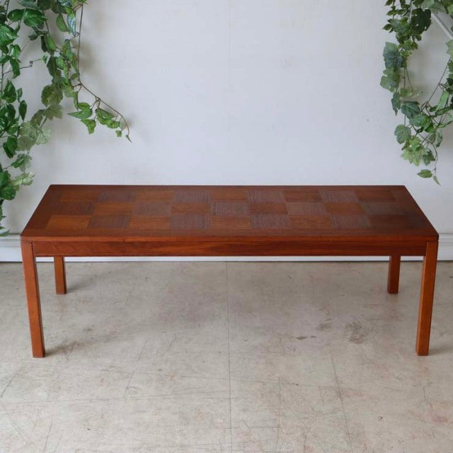 Vintage mid-century teak coffee table with British and Danish influences, showcasing a checkered rosewood grain top and.