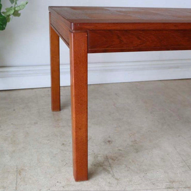Mid-century vintage teak coffee table with rich rosewood grain, clean square legs, and Scandinavian design influences.