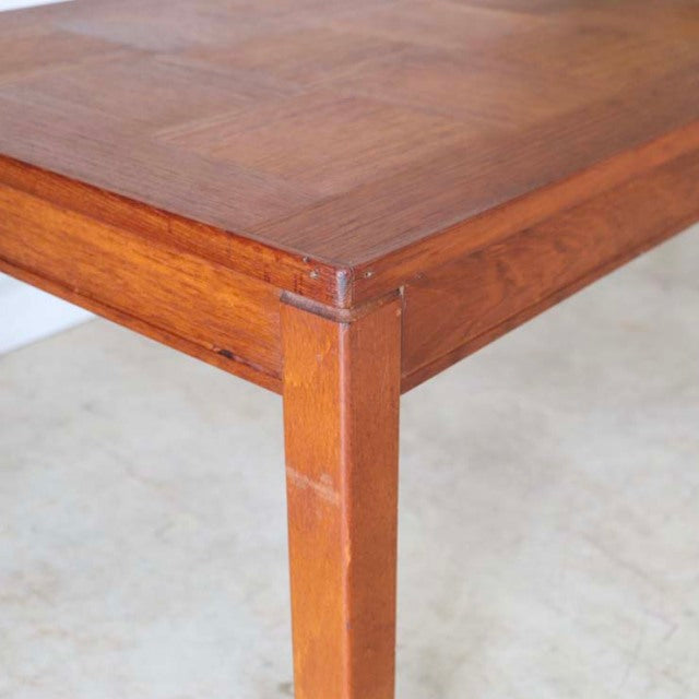 Vintage mid-century teak British coffee table with visible wood grain and square tapered legs from Denmark.