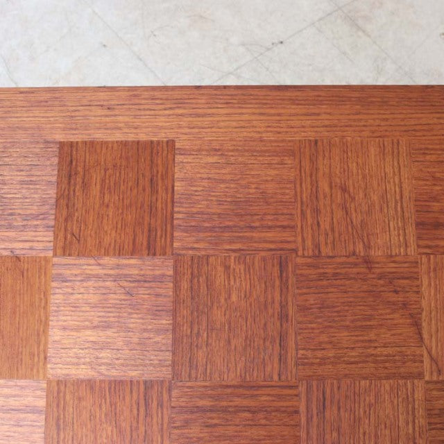 Close-up of vintage mid-century teak rosewood coffee table top with distinct grain pattern and square panel design.