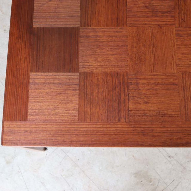 Corner detail of vintage mid-century teak rosewood coffee table with rich wood grain and sleek British-Denmark design legs.