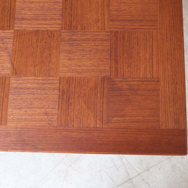 Close-up of vintage teak coffee table top showcasing detailed mid-century parquet wood grain from British-Danish design.