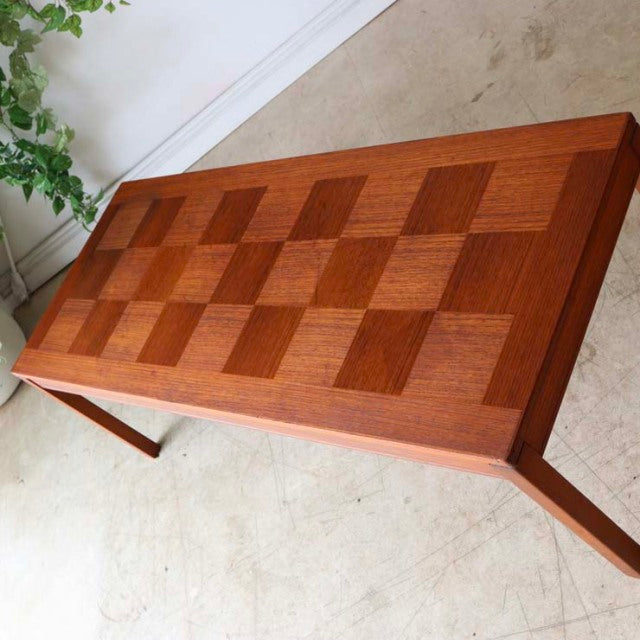 Mid-century vintage teak coffee table with checkerboard wood grain top and tapered legs, British-Denmark style.