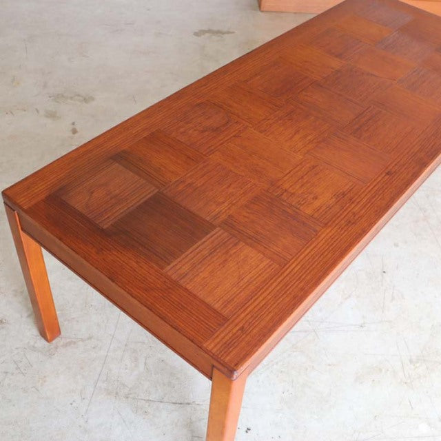 Mid-century vintage British teak coffee table with rosewood parquet top and slender tapered legs in Danish style.