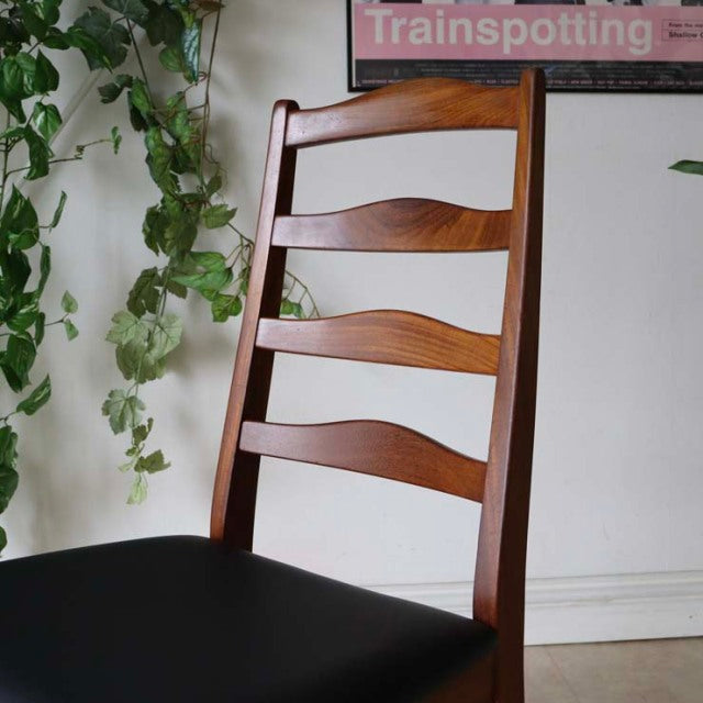 Set of four British mid-century G-Plan teak dining chairs with ladder backs and black upholstered seats in vintage Danish.