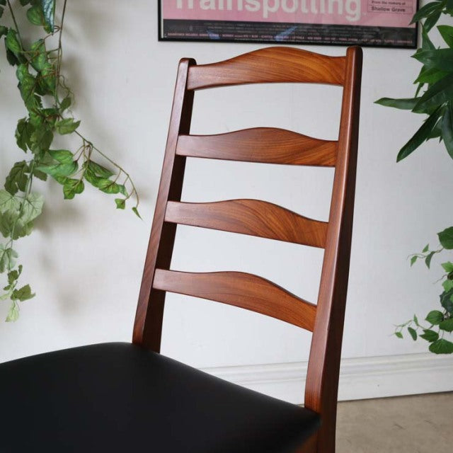 Set of four vintage G-Plan ladder back dining chairs in teak with tapered legs and molded seat, British mid-century design.