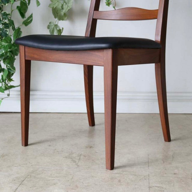 Vintage British mid-century teak G-Plan ladder back dining chair with black upholstered seat and tapered legs.