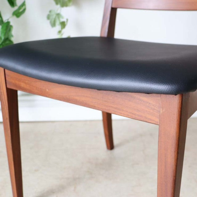 Set of four vintage British G-Plan mid-century teak ladder back dining chairs with black leather seats and tapered legs.