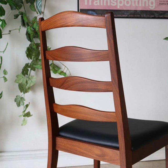 Set of four vintage G-Plan ladder back dining chairs in teak wood with visible grain and black leather seats, British.