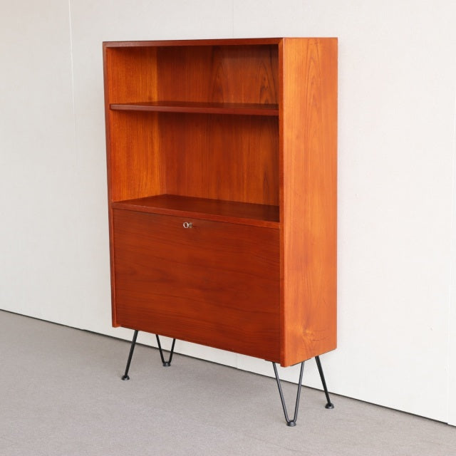 Vintage mid-century teak cabinet from Denmark featuring rich wood grain and slender black iron legs.