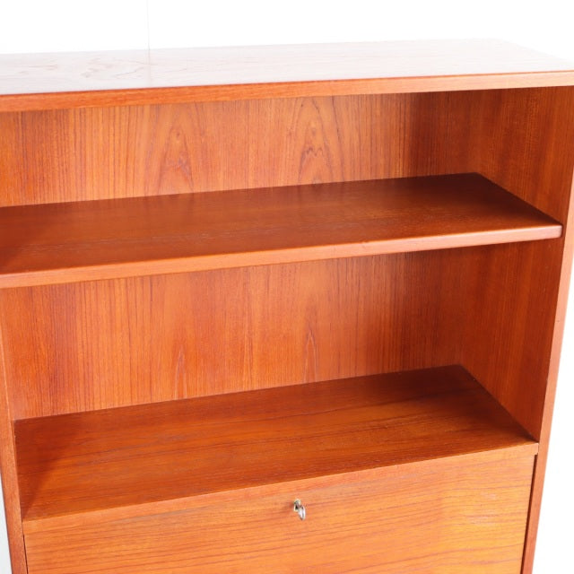 Vintage mid-century teak shelving unit with rich wood grain and iron legs, Danish design style.