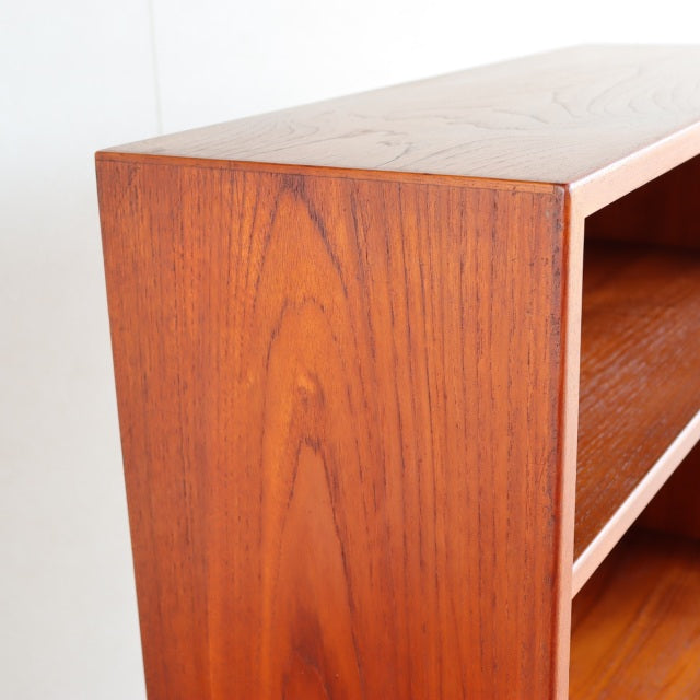 Mid-century vintage Danish teak cabinet with smooth wood grain and custom iron legs, sleek rectangular form.