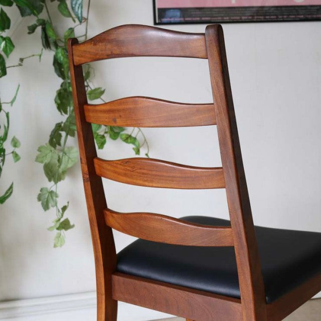 Set of four vintage British mid-century G-Plan teak ladder back dining chairs with black upholstered seats and smooth wood.