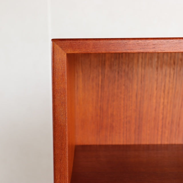 Mid-century vintage teak shelf with rich wood grain and clean Danish design, iron legs unseen in close-up.
