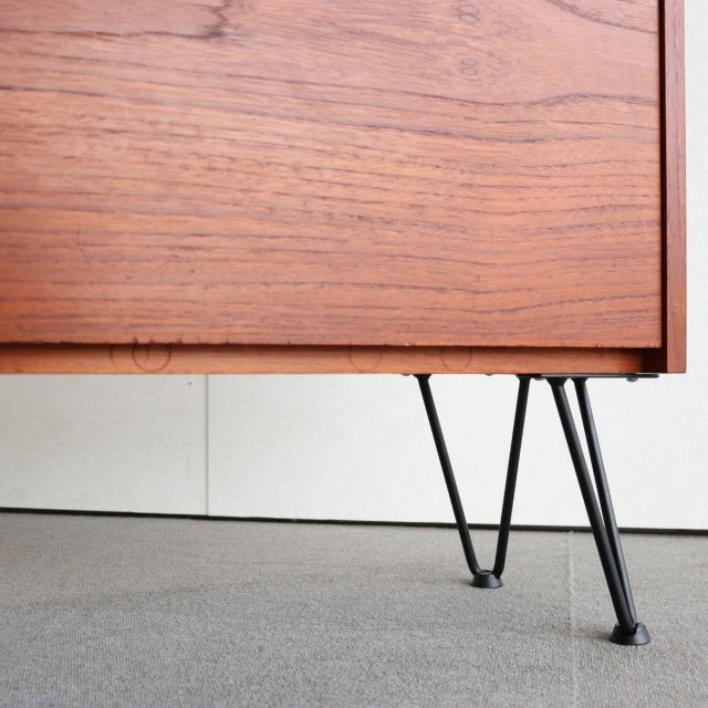 Mid-century vintage teak cabinet with distinctive black iron hairpin legs showcasing rich wood grain and Danish design.