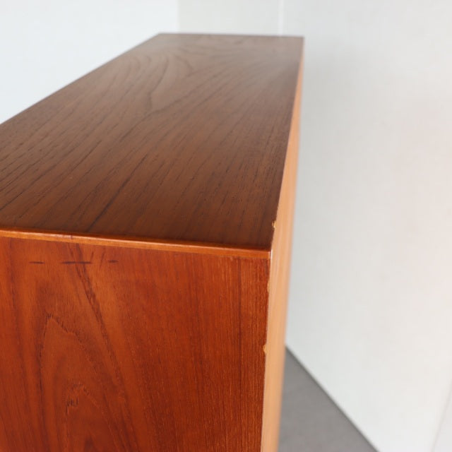 Mid-century vintage teak cabinet with rich wood grain and sleek iron legs, Danish design influences, British style cues.