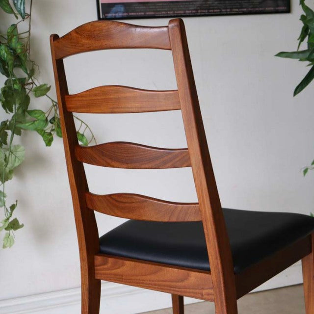 Set of four British vintage mid-century G-Plan ladder back dining chairs in teak with black leather seats and curved wood.