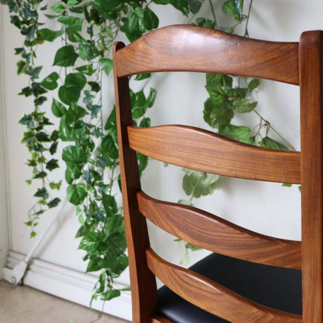 Set of four vintage G-Plan teak ladder back dining chairs with curved slats and mid-century British design.