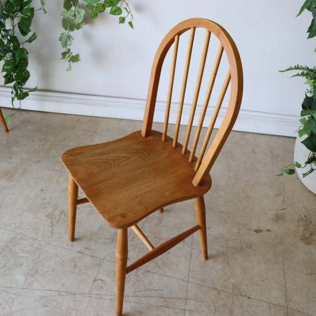 Vintage British mid-century teak Ercol hoop back dining chair with rounded spindle back and contoured seat showing natural.