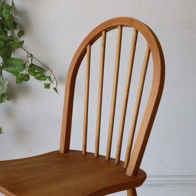 Mid-century British vintage Ercol hoop back dining chair in teak with curved spindles and smooth wood grain.