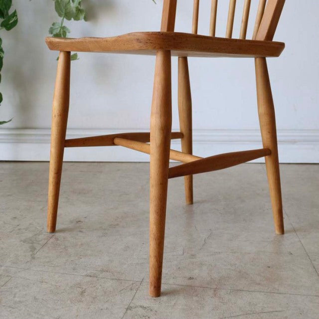 Mid-century British vintage ERCOL teak hoopback chair with smooth wood grain and tapered legs.