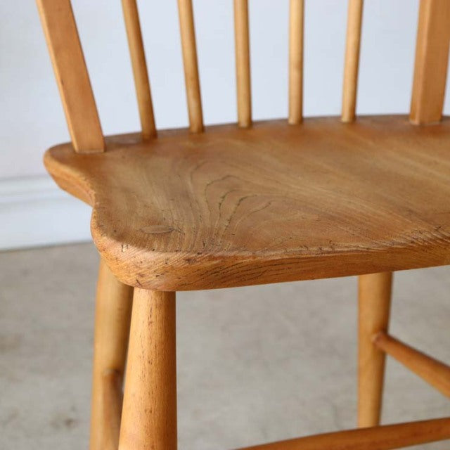 Vintage British mid-century Ercol hoop back dining chair in teak with smooth wood grain and rounded legs.