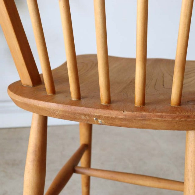 Vintage teak Ercol Hoop Back dining chair with slender spindle backrest and rounded seat, mid-century British design.