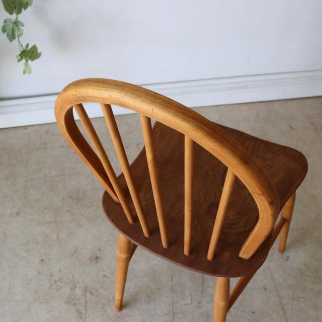 Vintage British mid-century Ercol teak dining chair with curved hoop back and visible wood grain.